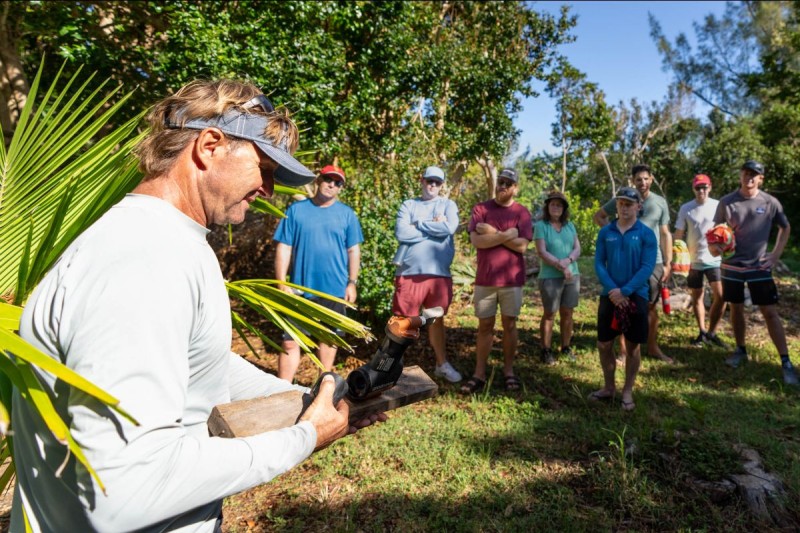 JP Skinner, the founder and director of Waterstart, shows competitors from the Bermuda Gold Cup a trap used to catch rodents on on Burt Island (Photo: Ian Roman/WMRT).