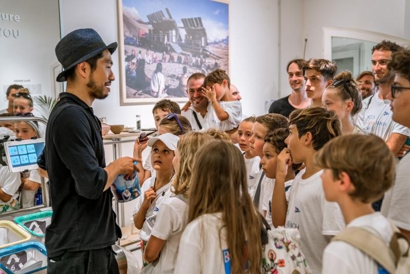 Arthur Huang, MINIWIZ CEO explains to the Sailing School kids how the MINIWIZ recycling lab works at the pop-up store at Promenade du Port